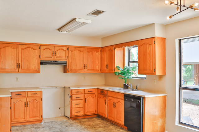 Kitchen with wood cabinets and modern lighting fixture in Oakdale LA home