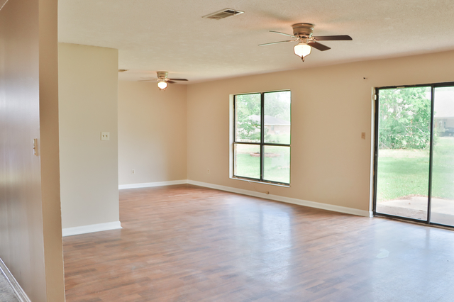 Spacious living room with wood-look laminate flooring and ceiling fan at 1512 Lisa Lane Oakdale LA